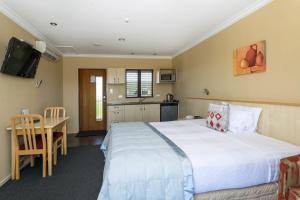 En eller flere senger på et rom på Blenheim Spa Motor Lodge