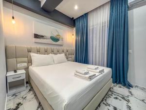 una camera da letto con letto e tende blu di Rumani 3 Islands Hotel a Ksamil