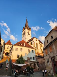 a building with a clock tower in a town at 4Rooms Central Sibiu in Sibiu