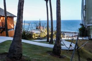 a view of the ocean from a house with palm trees at Apartamento em ótima localização in Salvador