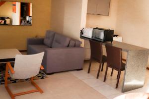 a living room with a couch and a table with a microwave at Apartamento em ótima localização in Salvador