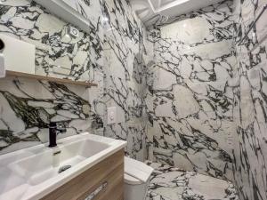 uma casa de banho com um lavatório e uma parede em mármore em Rumani 3 Islands Hotel em Ksamil