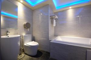 a bathroom with a tub and a toilet and a sink at Meng Siang Motel in Pingzhen