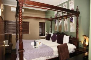 een slaapkamer met een hemelbed met witte lakens bij Moonriver Guesthouse in Upington