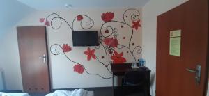 Un dormitorio con una pared con flores pintadas. en Hotelik SJ en Lodz