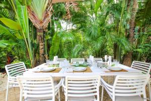 een witte tafel met witte stoelen en bomen bij Claridges 1 villa in Saint Peter