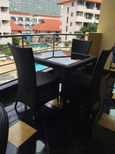 d'un balcon avec une table, des chaises et une piscine. dans l'établissement Jomtien Plaza Residence B408 By Mr.Kiss, à Jomtien Beach