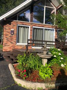 a house with a flower garden in front of it at Le chalet du Golf à Rimouski in Rimouski