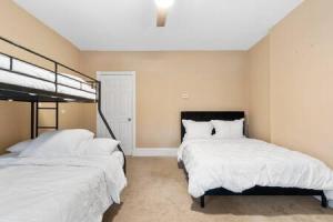貝永的住宿－Cozy Urban Escape I Near NYC，卧室内的两张床,配有白色的毯子和枕头