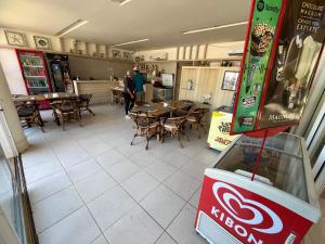 un restaurant avec des tables et des chaises et une machine à coca cola. dans l'établissement Beach Living - Apt com 2 Quartos - Pé na Areia, à Aquiraz