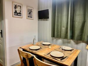 a wooden table with plates and wine glasses on it at Appartement Valloire, 2 pièces, 4 personnes - FR-1-263-529 in Valloire