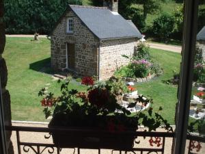 een raam met uitzicht op een tuin en een klein gebouw bij Les Basses Rouves Niort in Lassay