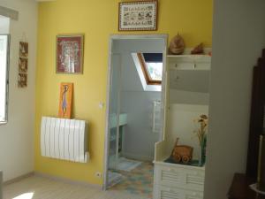 a room with a mirror and a yellow wall at Les Basses Rouves Niort in Lassay