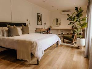 a bedroom with a large white bed and a desk at Fancy Fritz B&B in Swakopmund