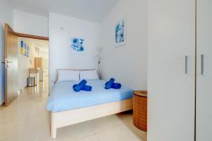 een slaapkamer met een bed met blauwe kussens erop bij Tranquil Retreat Steps from St Julians Action in St Julian's
