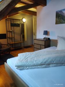 a bedroom with a bed and a dresser with a lamp at Gasthaus "Hotel Hirschen" in Beromünster