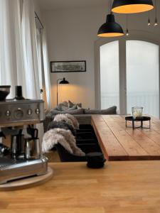 un soggiorno con divano e tavolo in legno di Exklusives Stadthaus-Apartment am Staatstheather a Cottbus