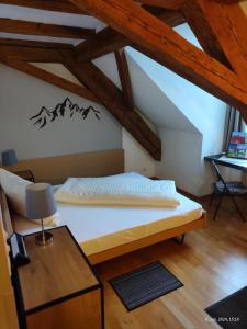 um quarto com uma cama e uma mesa num sótão em Gasthaus "Hotel Hirschen" em Beromünster