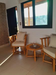 a room with two chairs and a table and a window at Anicca Posada in San Marcos Sierras