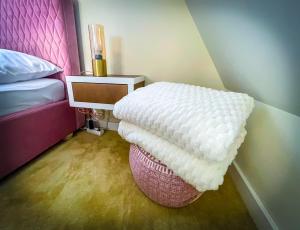 a bedroom with a bed and a white ottoman at Rosé de Lux in Bogács