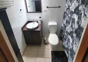 y baño con aseo blanco y lavamanos. en Son de Metro Apartment / near Distrito T-Mobile, en San Juan