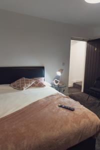 a bedroom with a bed with a remote control on it at Vault Chambers in Brierley Hill