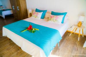 a bedroom with a large white bed with flowers on it at Matariki Sunset Apart Hotel in Hanga Roa