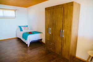 a bedroom with a bed and a large wooden cabinet at Matariki Sunset Apart Hotel in Hanga Roa +20 photos