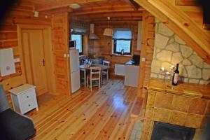 a kitchen and living room in a log cabin at Winnica Nad Źródłem - Domki w winnicy in Sierzawy