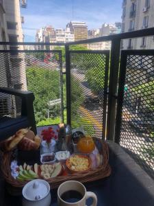 una bandeja de comida en una mesa en un balcón en Cómodo departamento con balcón en Microcentro en Buenos Aires
