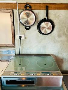 płytę kuchenną z dwoma garnkami i patelnią w obiekcie ギャラリー宿　INNAHOUSE ANDAGALLERY w mieście Murotsu