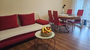 ein Wohnzimmer mit einem Sofa und einem Tisch mit einer Schale Bananen in der Unterkunft Palma Guesthouse in Rab