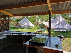 un groupe de tentes dans une cour avec une table dans l'établissement Bell tent Glamping Essenhof, à Aagtekerke