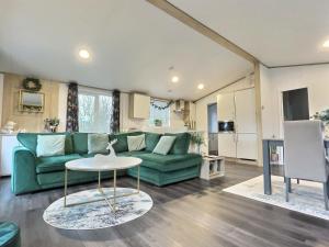 a living room with a green couch and a table at Coniston View 7 in Warton