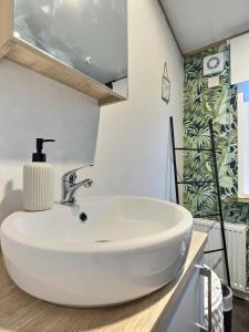 ein weißes Waschbecken im Bad mit grüner Wand in der Unterkunft Coniston View 7 in Warton