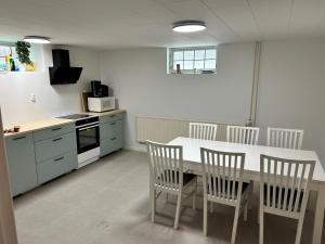 a kitchen with a table and chairs in a room at Vrigstad Rumshotell in Vrigstad