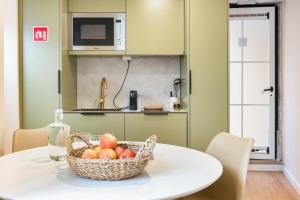 a basket of fruit on a table in a kitchen at Metropolitan Living Lisbon - Laranjeiras in Lisbon