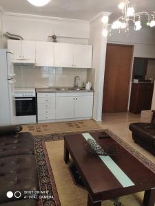 a living room with a table and a kitchen at Fay's home in Thessaloniki