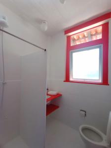 een badkamer met een toilet en een raam bij Buzios Praia Caravelas cs 11 in Baía Formosa