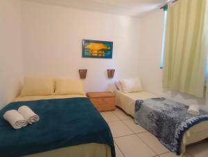 een slaapkamer met 2 bedden en een raam bij Buzios Praia Caravelas cs 11 in Baía Formosa