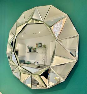 a mirror hanging on a green wall with a kitchen at Coastal Vibes - Stunning Bournemouth Apartment with King Size Bed and Free Parking - Central Location and Close to Beach in Bournemouth