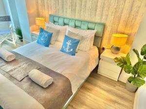 a bedroom with a bed with blue and white pillows at Coastal Vibes - Stunning Bournemouth Apartment with King Size Bed and Free Parking - Central Location and Close to Beach in Bournemouth