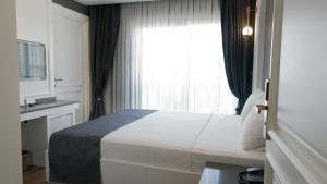 a hotel room with a bed and a window at Mai İnci Otel in Antalya
