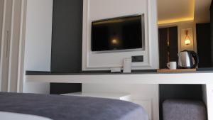 a bedroom with a tv on a desk with a bed at Mai İnci Otel in Antalya