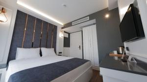 a hotel room with a bed and a television at Mai İnci Otel in Antalya