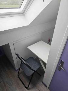a chair in a room with a table and a window at Purple Baroque Rer C -N104-A6 in Brétigny-sur-Orge