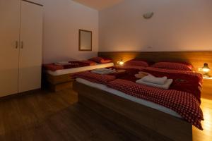 - une chambre avec 2 lits et des couettes rouges dans l'établissement Apartma Planika, à Kranjska Gora