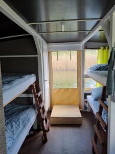 a room with three bunk beds and a window at Floss Priepert 1 in Priepert