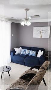 un sofá azul en una sala de estar con techo en Apto Praia da Enseada 4 pessoas en Guarujá