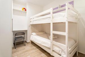 バレンシアにあるAPARTAMENTO DE ENSUEÑOの白い二段ベッド(椅子付)が備わる客室です。
